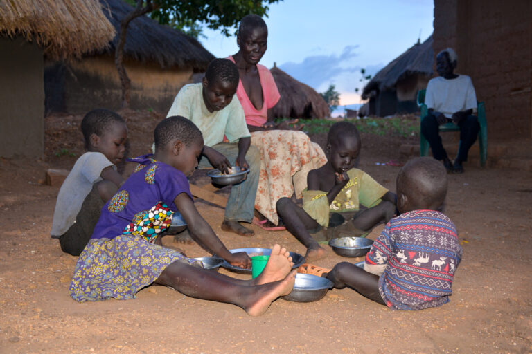 Children in North East Uganda take younger siblings to school for food in hunger crisis