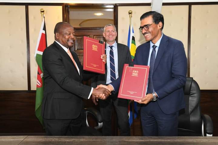 Health CS Mutahi Kagwe exchange documents after signing of MoU with a Danish pharmaceutical