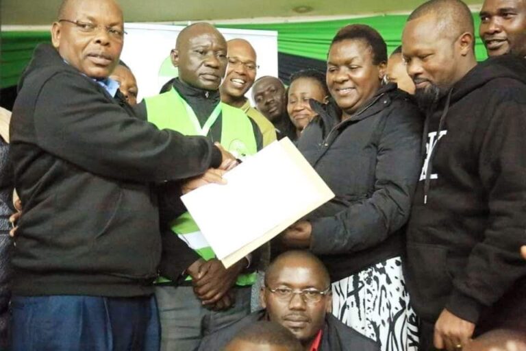 Kisii Returning officer Michael Kosgey hands over a certificate to Dorice Donya
