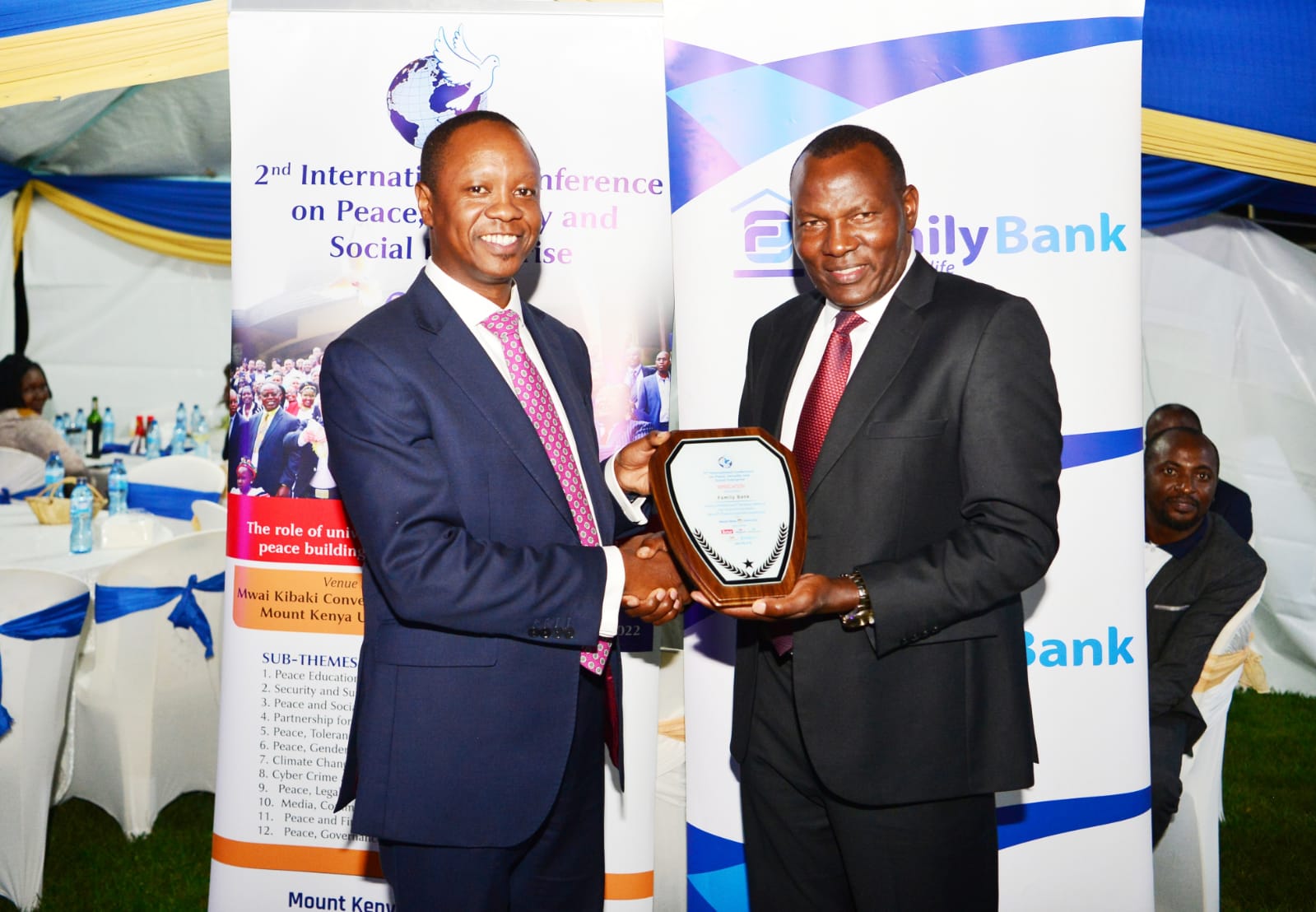 Family Bank Chief Commercial Officer, Ken Kaniu(l) receives a gift