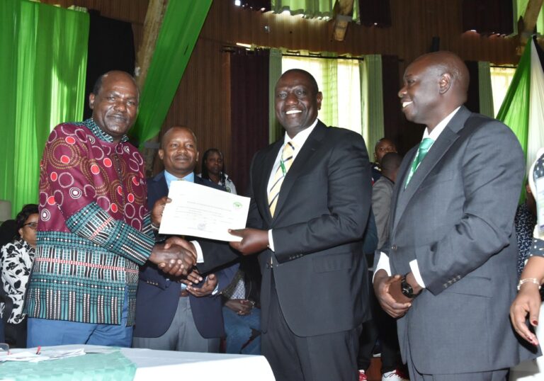 IEBC Chairperson Wafula Chebukati (left) presents a clearance certificate to UDA presidential candidate William Ruto...