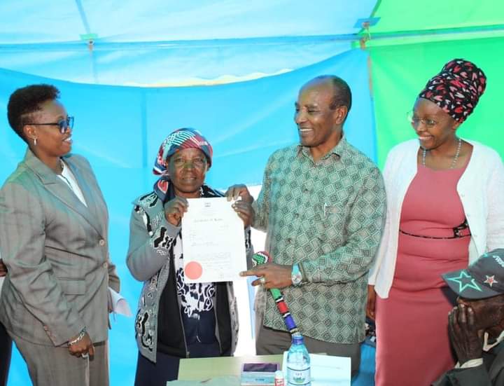 Nyandarua County Governor Francis Kimemia issuing Title Deed to one of the beneficiaries.