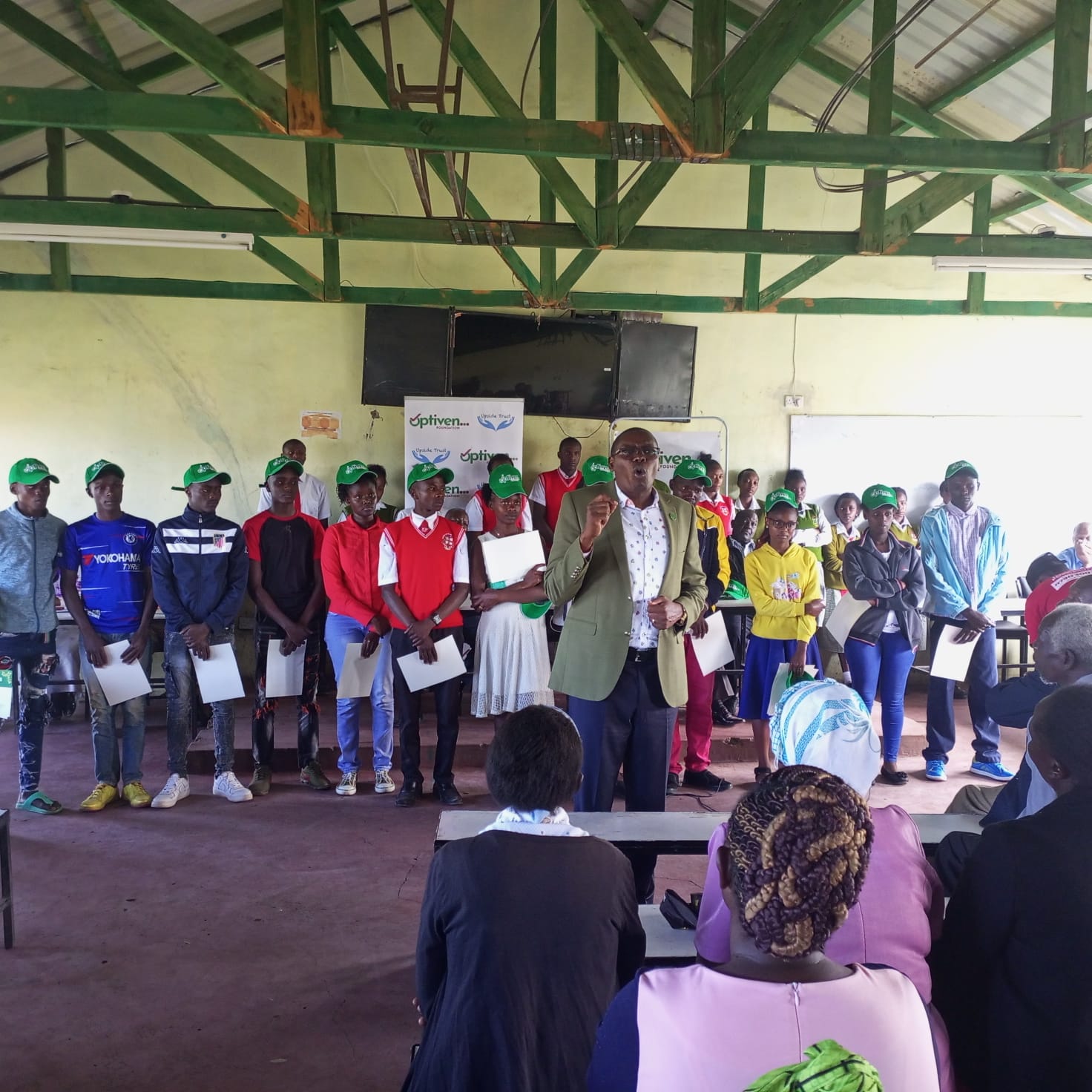 Optiven Foundation chairman George Wachiuri speaking to students, teachers parents and beneficiaries of the Scholarship at Labbura Secondary Schoo, Kieni, Nyeri County yesterday .
