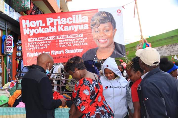 Priscila Nyokabi interacting with Nyeri town business community besides her banner. She is seeking senatorial seat under Jubilee party.