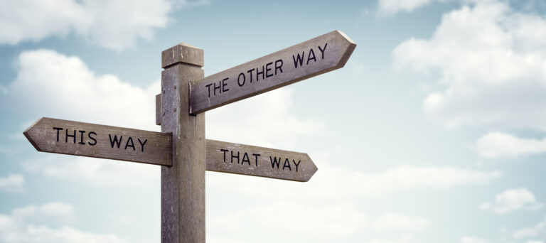 Crossroad signpost saying this way, that way, the other way conc