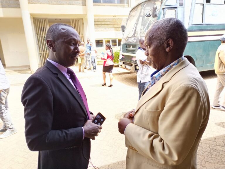 Kieni MP Njoroge Wainaina alias Chieni (right) confers with his lawyer Muhoho Gichimu