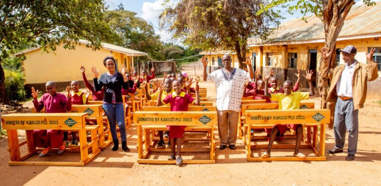 Kyaume Primary School pupils and teachers celebrating delivery of new desks by Kakuzi PLC.