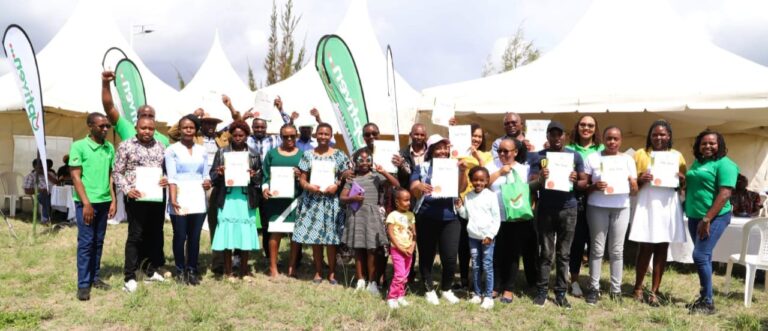 Some of the beneficiaries of land ownership through the partnership between Optiven Real Estate and Tuskys supermarket displaying their Title Deeds at Garden of Joy in Machakos on Saturday.