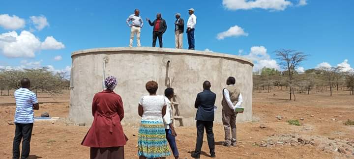 Laikipia County Deputy Governor Reuben Kamuri (in a red shirt on top of the water tank) when he visited a water project in Segera ward.