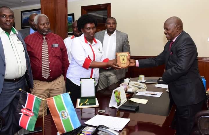 Nyeri County governor Mutahi Kahiga (right) receiving the award from ASK National chairperson Annabelle Kirinya as other officials looks on.