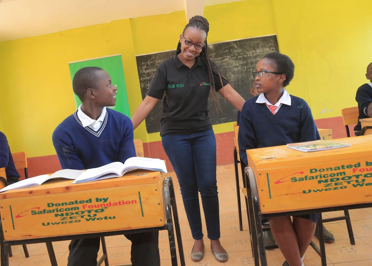 Ms Catherine Mugweru from Safaricom PLC interacting with students from St. Mary's Kiaragana Mixed secondary school in Ndia constituency