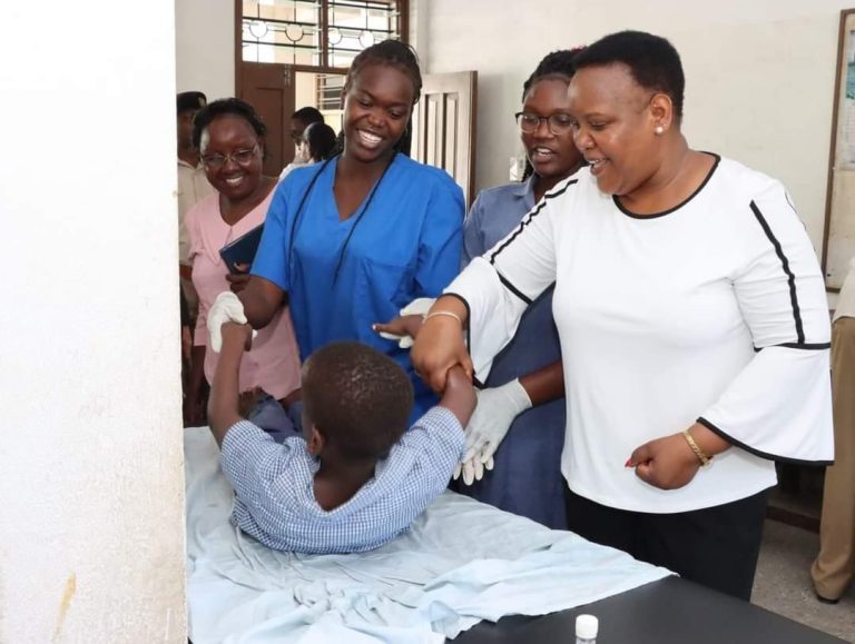 Cabinet Secretary, Florence Bore in white with a celebral palsy child