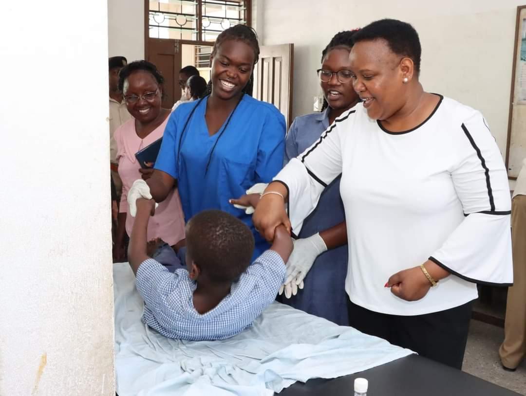 Cabinet Secretary, Florence Bore in white with a celebral palsy child