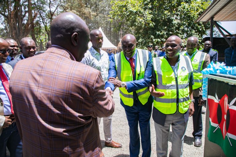 Deputy President Rigathi Gachagua greeting Tana Water Works Development Agency Chairman Wanyaga Gathaka as Principal Secretary for Water Dr Ronoh looks on shortly before he commissioned a borehole at Kianyaga High school