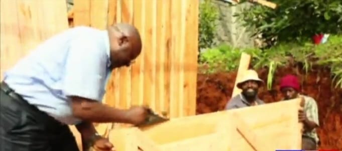 MP Wambugu Wainaina working on a door for one of the beneficiaries' houses.