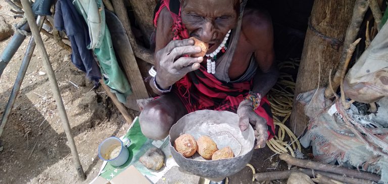 An elderly man struggles to squeeze some juice