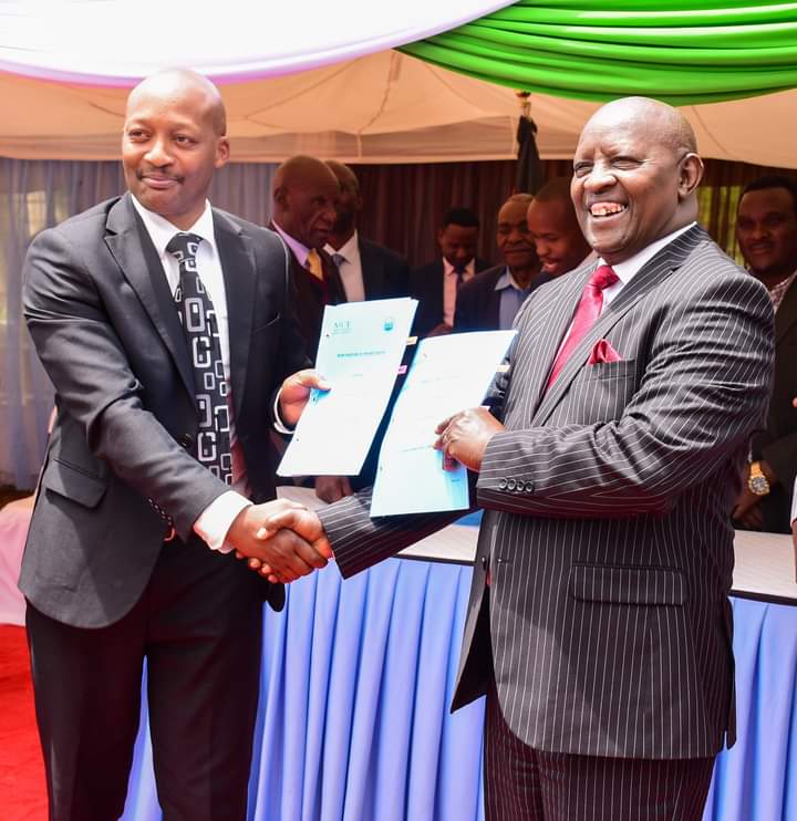 Nyeri County governor Mutahi Kahiga exchanging documents with NICE Managing Director Solomon Mburu