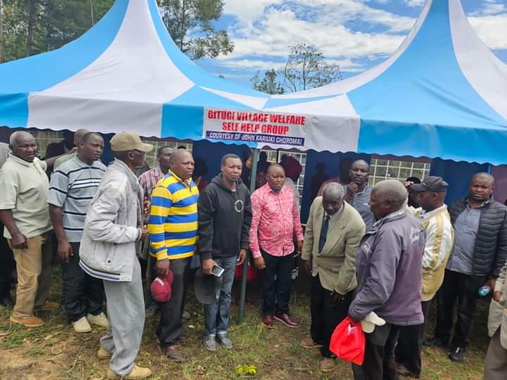 Philanthropist John Kariuki Choromai (in red shirt) with members Gitugi Welfare Group who were one of the beneficiaries