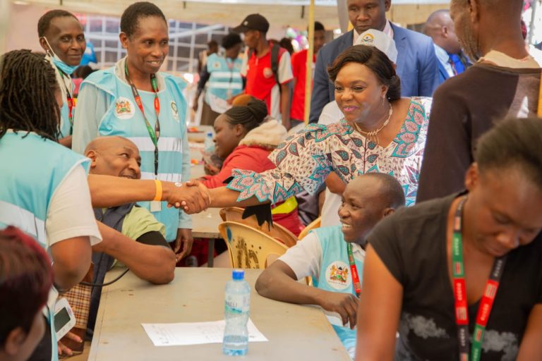 Pastor Dorcas Rigathi greeting medics treating drivers and conductors during a free medical camp yesterday.
