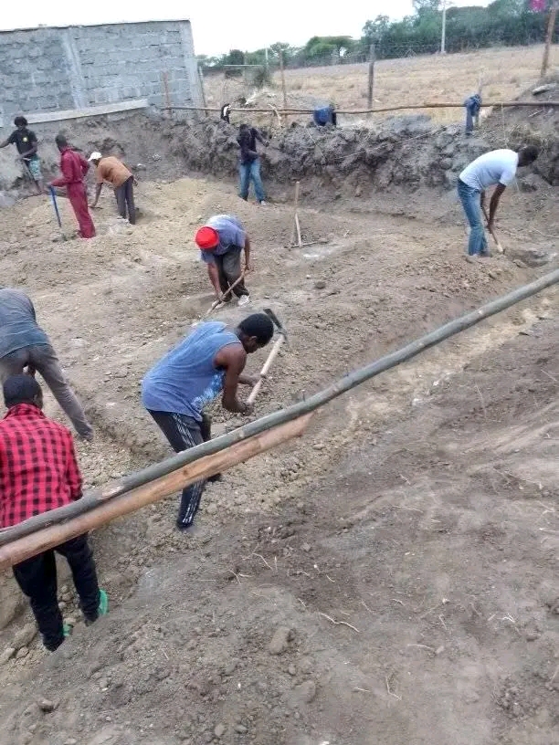 People working in a construction site without protective gear