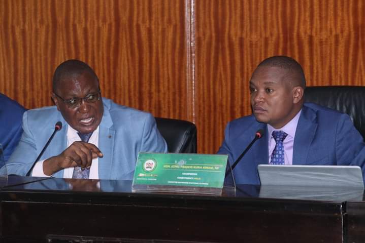 Committee chairman Kuria Kimani and a colleague during the session