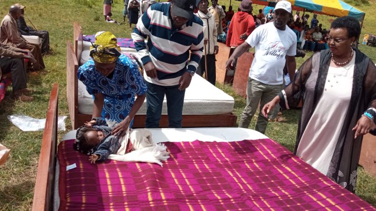 Ahadi Kenya Executive Director Stanley Kamau giving beds and blankets to senior citizens in Mathioya, Murang’a County.