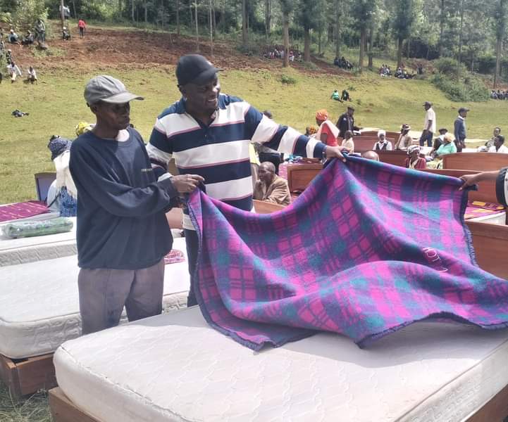 Ahadi Trust Kenya CEO Dr Stanley Kamau (right) showcasing some of the relief supplies that were donated to the needy at Karunge, Mathioya last Friday.