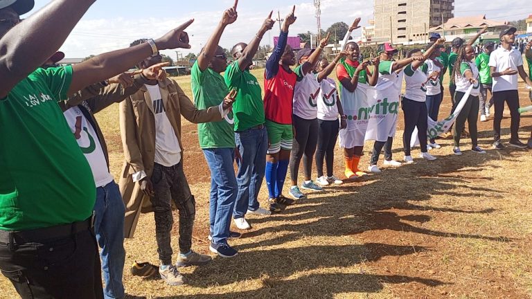 Optiven Chief Executive Officer Dr George Wachiuri (4th left) with some of his staff members cheering their firm's football team yesterday at Mweiga stadium