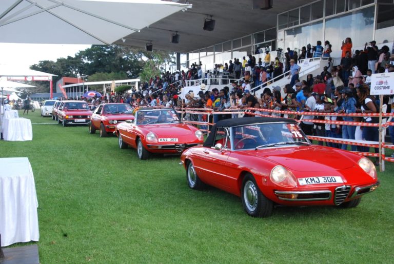 Spectators cheer the Alfa Romeo cars during the grand parade at the last Concours d'Elegance
