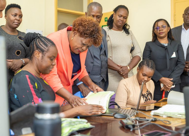 Lands CS Alice Wahome perusing documents with ministry officers based in Kiambu.