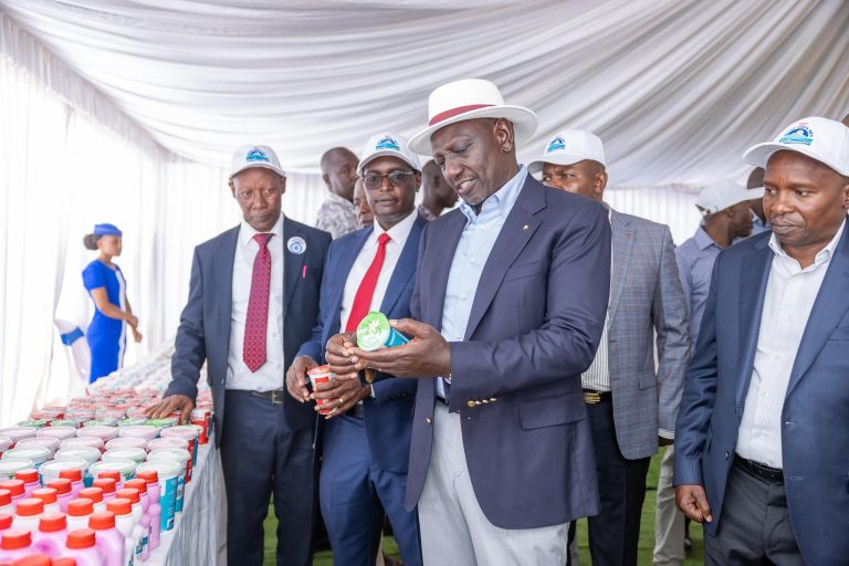 President William Ruto looks at some of products from Meru dairy as CEO Kenneth Gitonga (Center) and chairman Simon Kiruja (left) looks on.