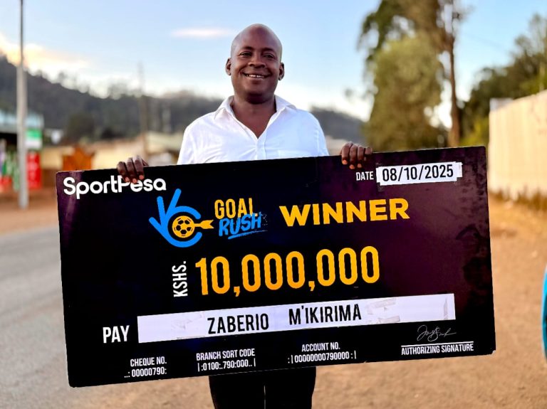 KSh10 million sportpesa Goal Rush winner Zaberio Mutura M'ikirima with a dummy cheque in Maua town after winning.
