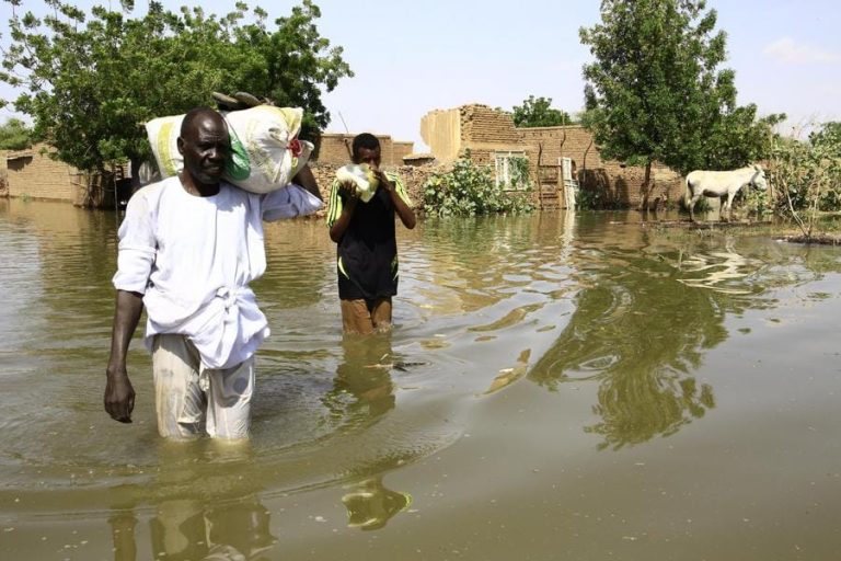 Residents wade through floodwater after the Nile River flooded their village in Bahri city, north of Khartoum, Sudan on Wednesday.