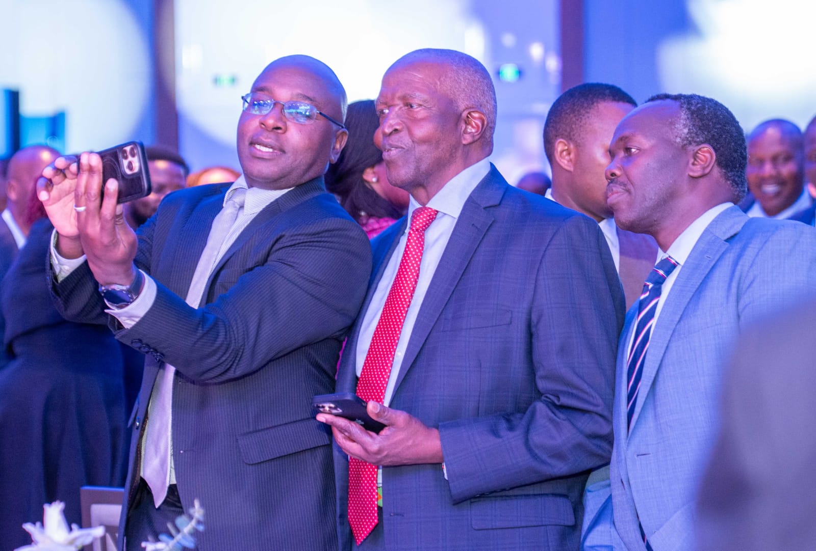 KRA Commissioner General Humphrey Wattanga takes a selfie with SanlamAllianz Kenya Chairman Dr John Simba and IRA CEO Godfrey Kiptum