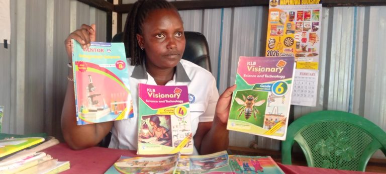 Maureen Kagwiria Headteacher in charge of KAN academy in Nchiru Tigania West shows some of the books used in the CBE.