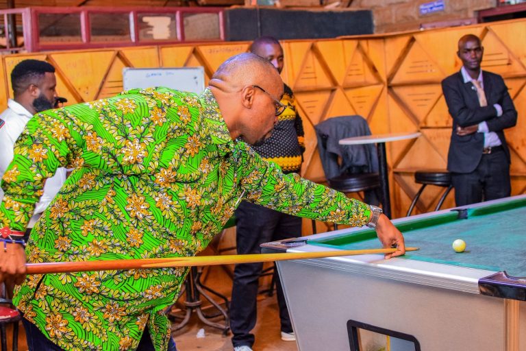 Nick Mararo trying his hand in a Pool game in Nyeri town.