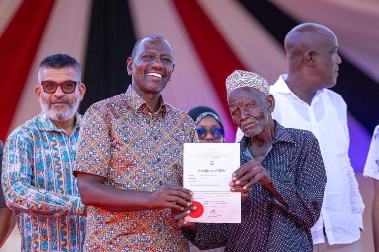 President William Ruto presenting a Title Deed to one of the beneficiaries.