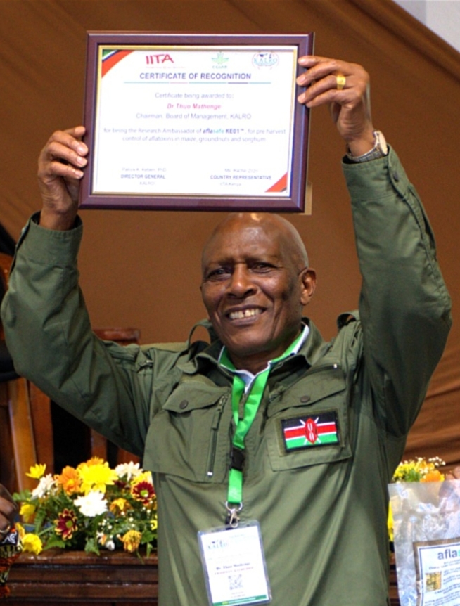KALRO chairman Dr Thuo Mathenge displaying a certificate of his appointment as AFloSave ambassador.