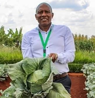 Kalro Chairman Dr Thuo Mathenge holding a cabbage in a past exhibition forum.