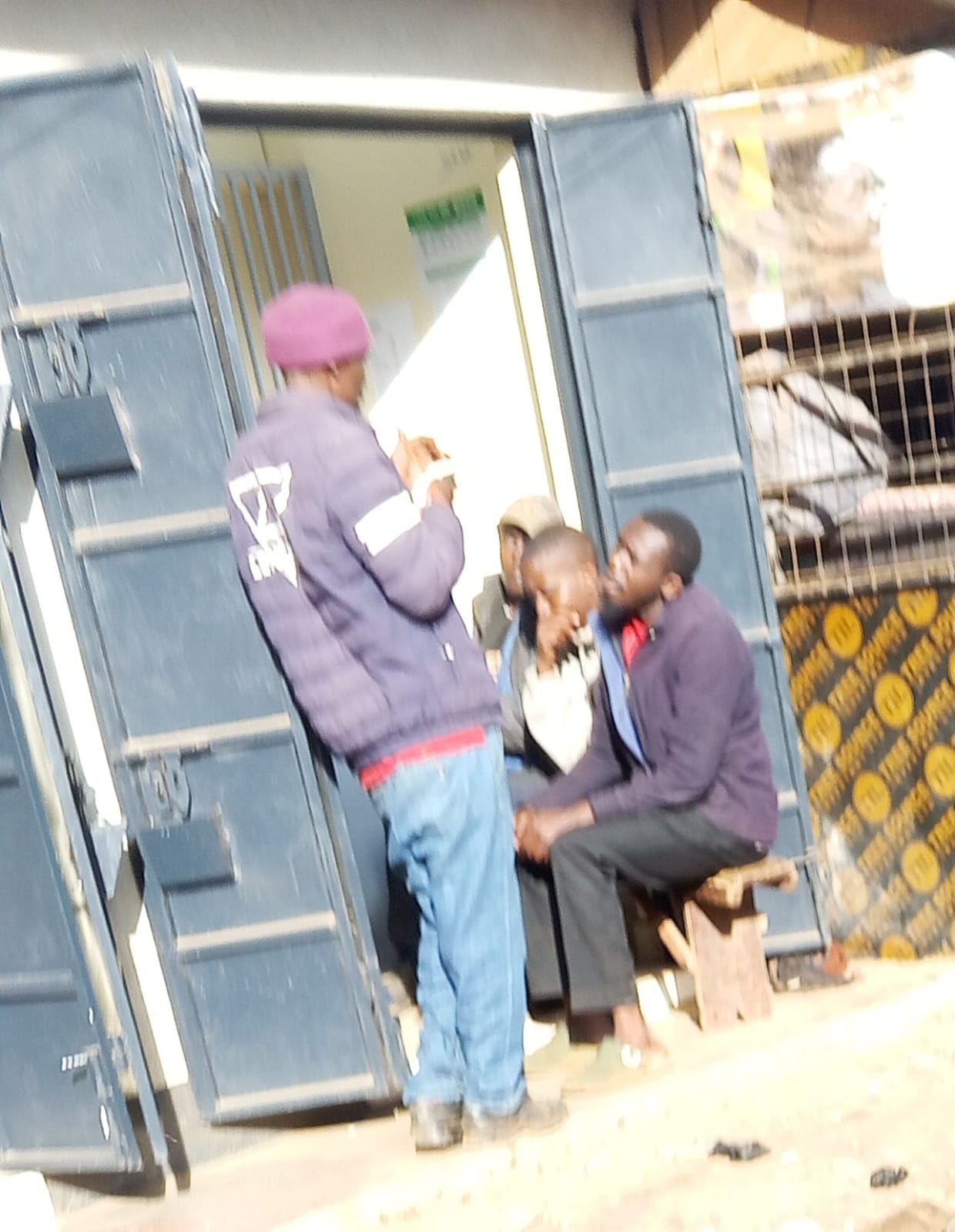 Patrons queuing for a shot (unlock) at a Witeithie wine and spirits outlet at night