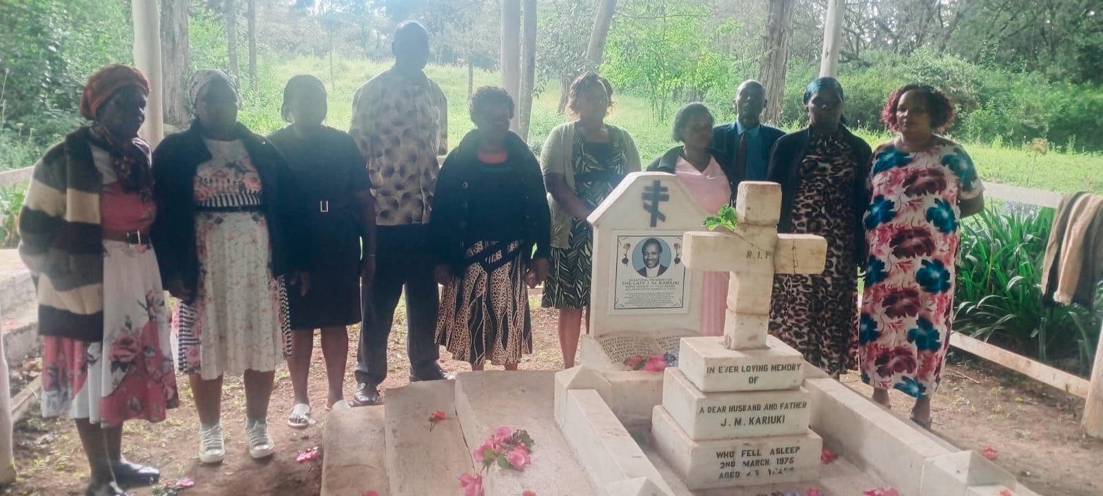 Some of MMV Associates CLG members and JM Kariuki's wife at his graveside.