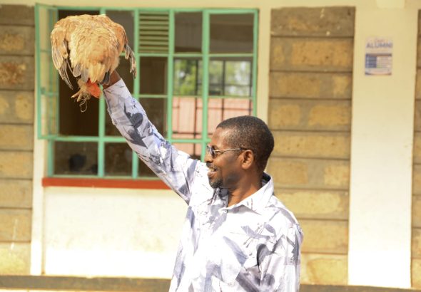 Dr Patrick Bucha hold a hen at the Nchaure Primary and Junior School Fundraiser.