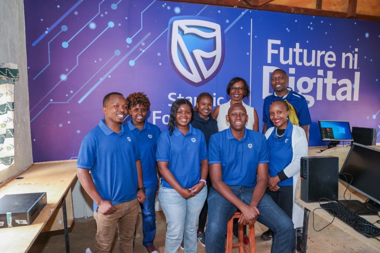 Staff of the Stanbic Kenya Foundation during the handover; The Head of Stanbic Foundation, Mercy Githanji addresses students of ACK Kiamuringa School in Embu County