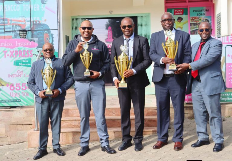 Tower DT sacco officials holding trophies awarded to the sacco during ushirika day celebrations.