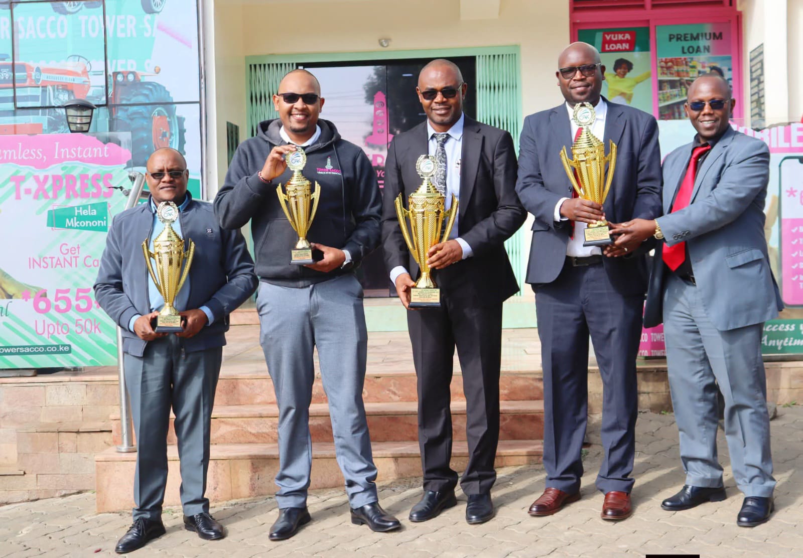 Tower DT sacco officials holding trophies awarded to the sacco during ushirika day celebrations.