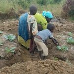 A mother cultivates a permagarden with her children Photo Credit The Permagardens Foundation