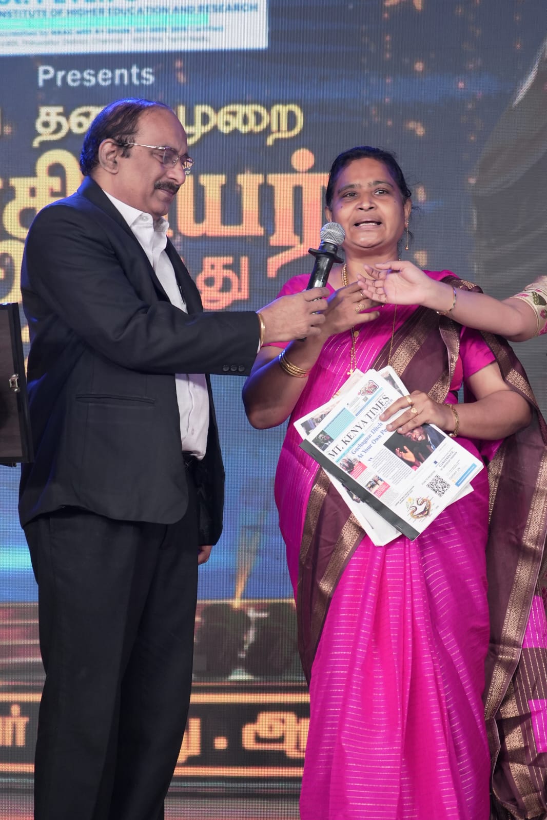 D. Brinda proudly holds The Mt Kenya Times international newspaper during the award ceremony.