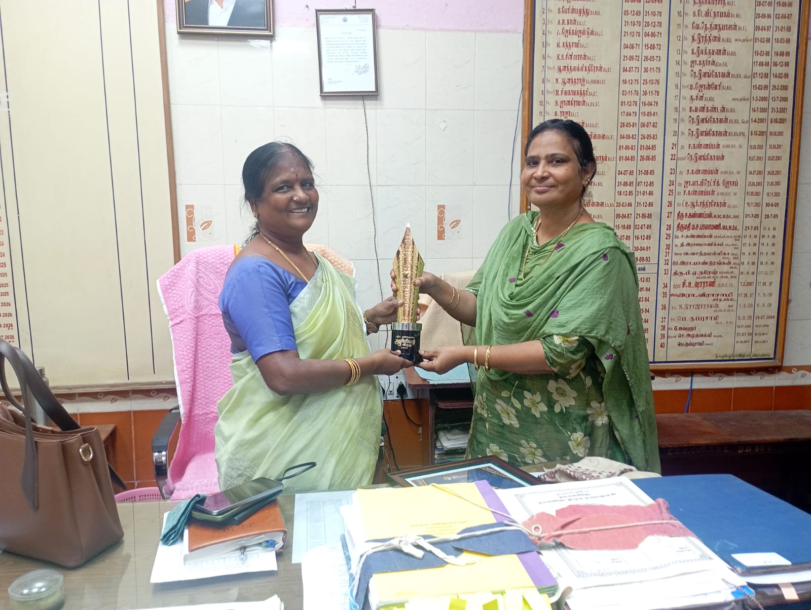 D. Brinda receives award from education officer.