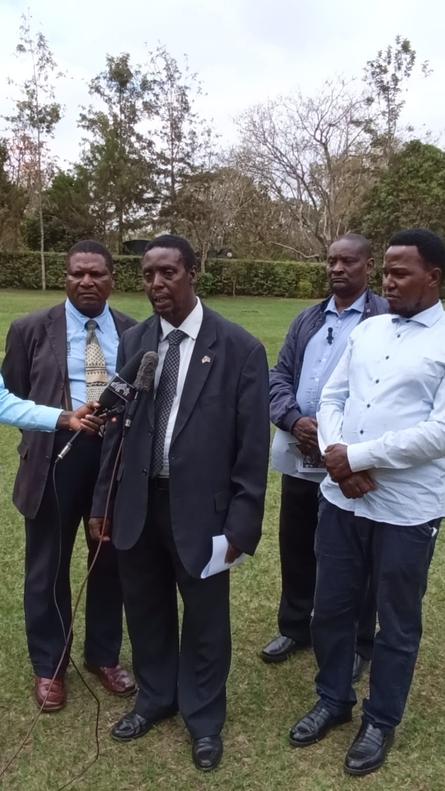 New chairman Dr Paul Mwangi Gatundu addressing the media as Bishop Johnson Mwai (left)