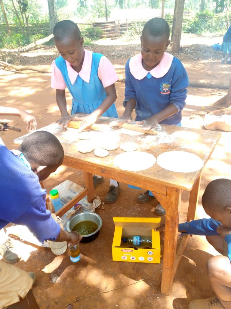 Students practicing a practical skill on chapati making
